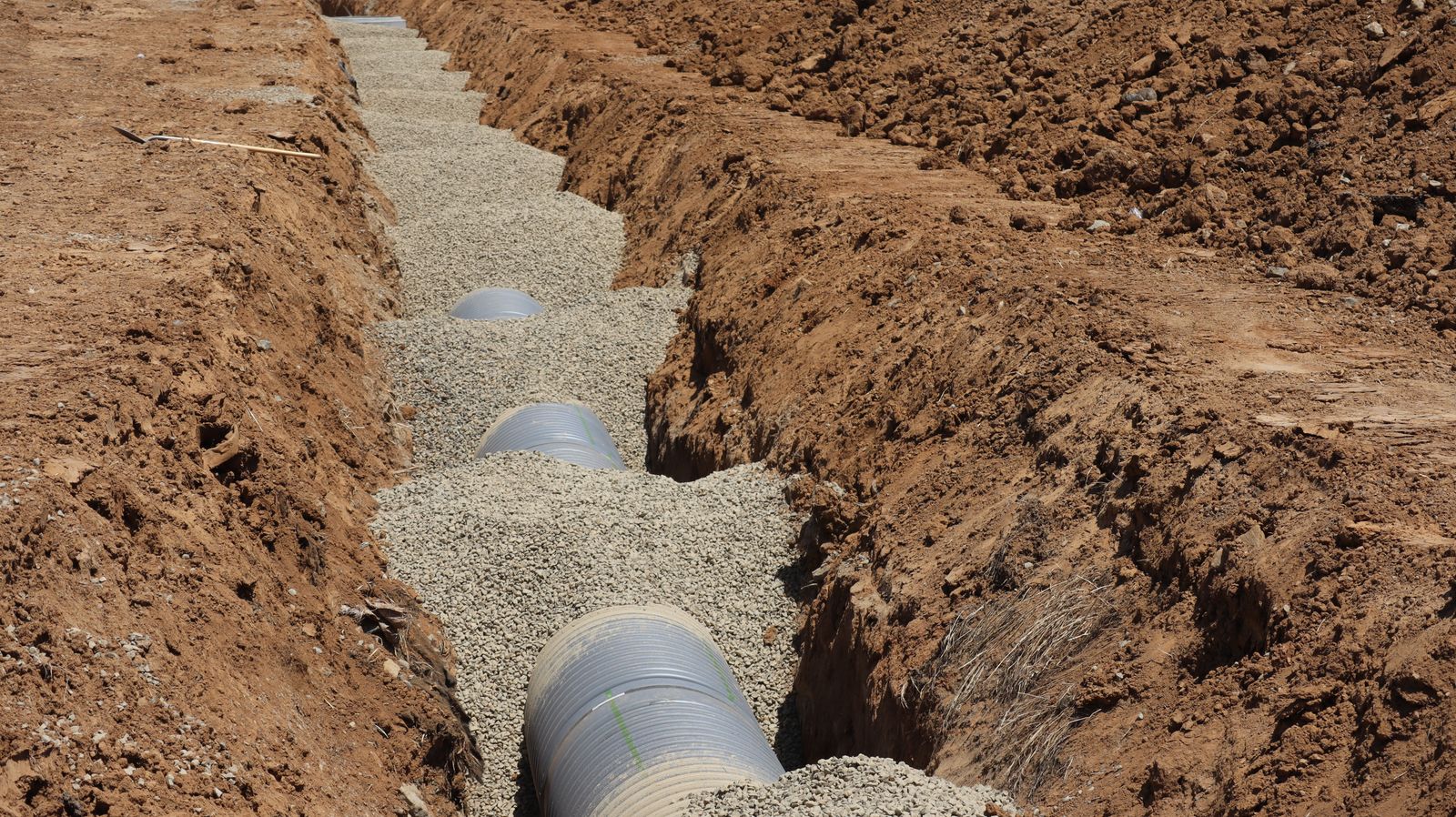 Open utility trench with exposed pipe